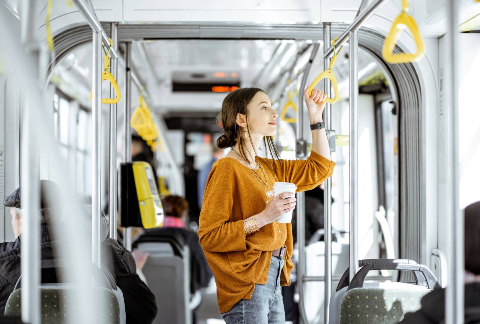 A woman standing on a bus.